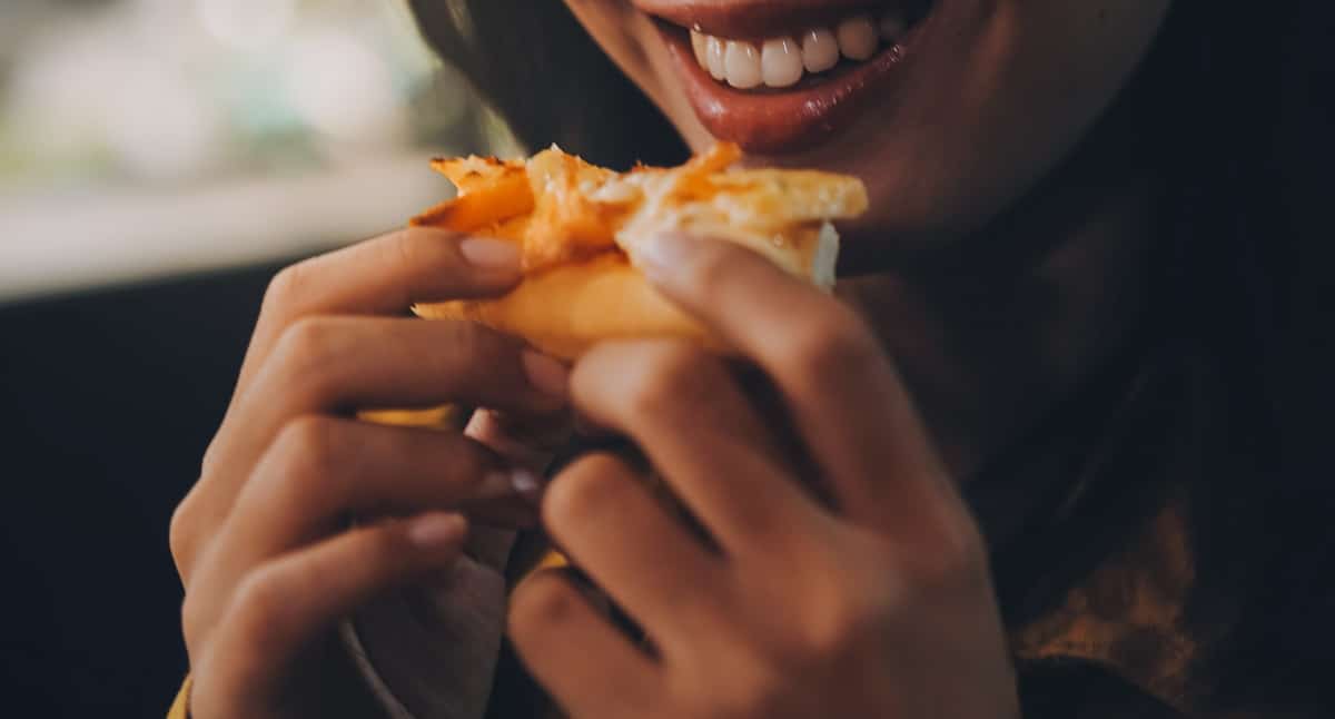 vecteezy funny brunette girl in yellow sweater eating pizza at 49307559